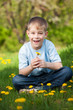 funny boy with dandelions in a green park. summer