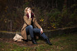 Young blond woman in autumn forest