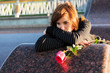 Sad young woman with a red rose