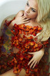 Beautiful sexy blond woman in water with flowers