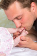 Father kissing baby feet