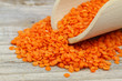 Dry red lentils in wooden scoop, close up