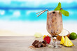 Summer cocktail with pieces of fruit on wooden table