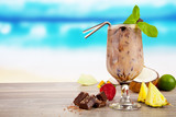 Summer cocktail with pieces of fruit on wooden table