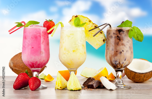 Photo: Summer cocktails with pieces of fruit on wooden table Summer cocktails with pieces of fruit on wooden table