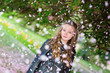 Photo : Girl under falling pink petals on a spring day Girl under falling pink petals on a spring day