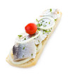 Sandwich with herring, onions, cherry tomato and herbs, isolated