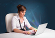 Beautiful woman sitting at desk and typing on laptop with abstra