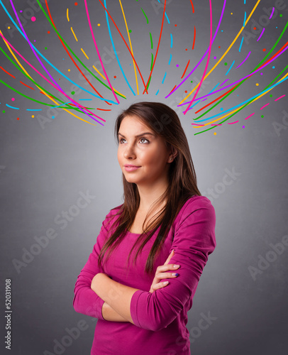 Photo: Young girl thinking with colorful abstract lines overhead Young girl thinking with colorful abstract lines overhead