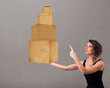 Photo: Young lady holding a set of brown cardboard boxes Young lady holding a set of brown cardboard boxes