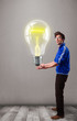 Attractive man holding realistic 3d light bulb
