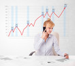 Photo: Young businesswoman calculating stock market with rising graph i Young businesswoman calculating stock market with rising graph i