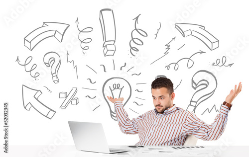 Photo: Young businessman brainstorming with drawn arrows and symbols Young businessman brainstorming with drawn arrows and symbols