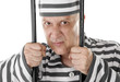 Angry convict prisoner jailbird behind bars