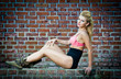 girl in swimsuit posing provocatively in front of a brick wall