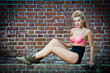 girl in swimsuit posing provocatively in front of a brick wall