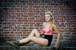 girl in swimsuit posing provocatively in front of a brick wall