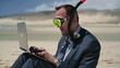 Businessman in diving mask working on laptop on the beach
