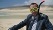 Happy businessman in diving mask on the beach