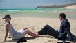 Happy business couple relaxing on beautiful beach