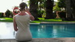Businesswoman talking on cellphone by the swimming pool