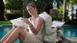 Businesswomen working with documents by the swimming pool