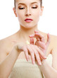 Young woman putting cream on her face