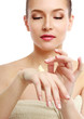 Young woman putting cream on her face
