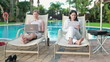 Two businesswomen working with documents and laptop by the pool