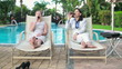Successful businesswomen drinking beer by the swimming pool