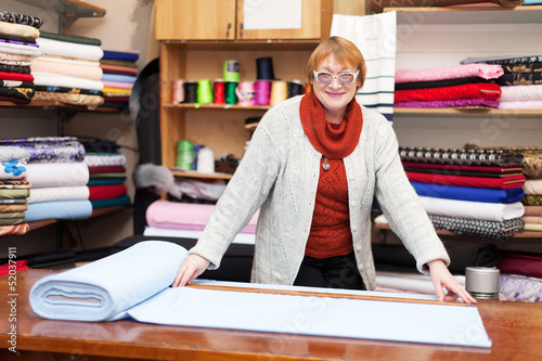 Photo: salesclerk measures the fabric salesclerk measures the fabric