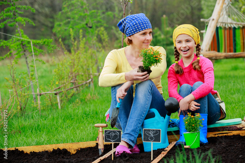 Photo: Gardening, planting - girl helping mother in the garden Gardening, planting - girl helping mother in the garden