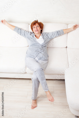 Photo: Happy mature woman on sofa Happy mature woman on sofa