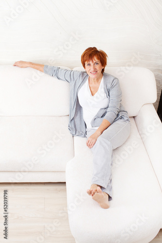 Photo: Happy mature woman on sofa Happy mature woman on sofa