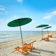 Beach chairs and umbrella on beach.