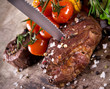 Delicious beef steaks with knife on wooden table
