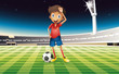 A boy with a soccer ball standing in the soccer field