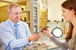 Optician selling glasses to customer