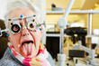 Woman with trial frame sticking out tongue
