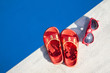 Colored sandal and sunglasses by the swimming pool