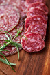Foto: Salami and rosemary on wooden chopping board Salami and rosemary on wooden chopping board