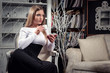 Young beautiful woman drinking coffee in luxury vintage interior