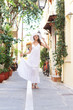 Photo: Young and beautiful lady walking down the ancient street Young and beautiful lady walking down the ancient street