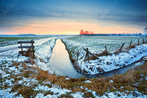 Photo: dramatic sunset over frozen river dramatic sunset over frozen river