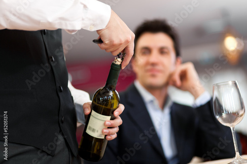 Photo: Waiter serving wine to a customer Waiter serving wine to a customer