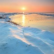 colorful sunset at the snowy Baltic sea shore
