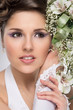 Young and beautiful bride standing with the flower bouquet