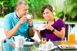 Photo: Asian couple having coffee on home porch Asian couple having coffee on home porch