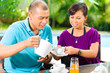 Asian couple having coffee on home porch