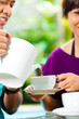 Foto: Asian couple having coffee on home porch Asian couple having coffee on home porch